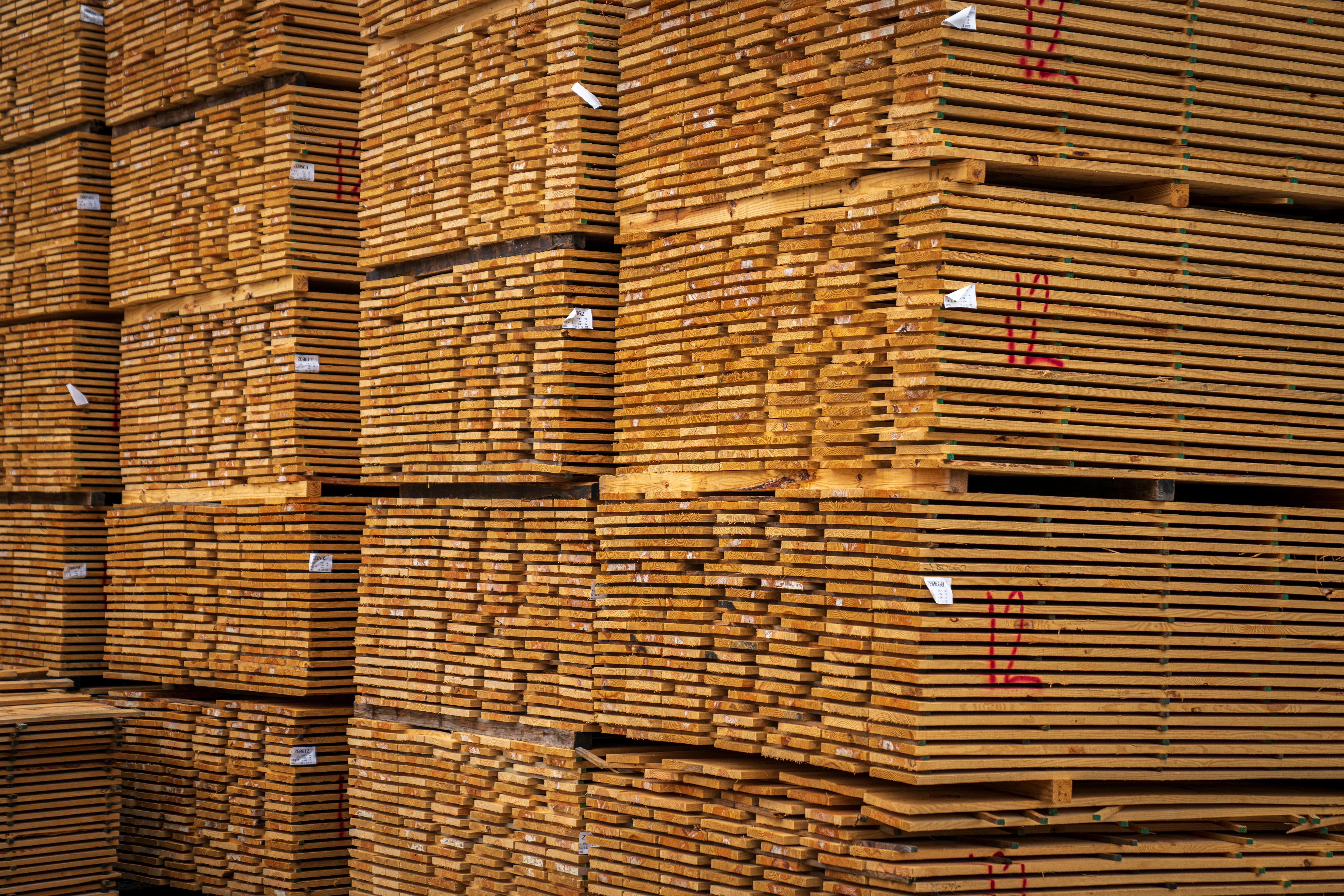 Close-up of neatly stacked wooden planks in an indoor warehouse setting.