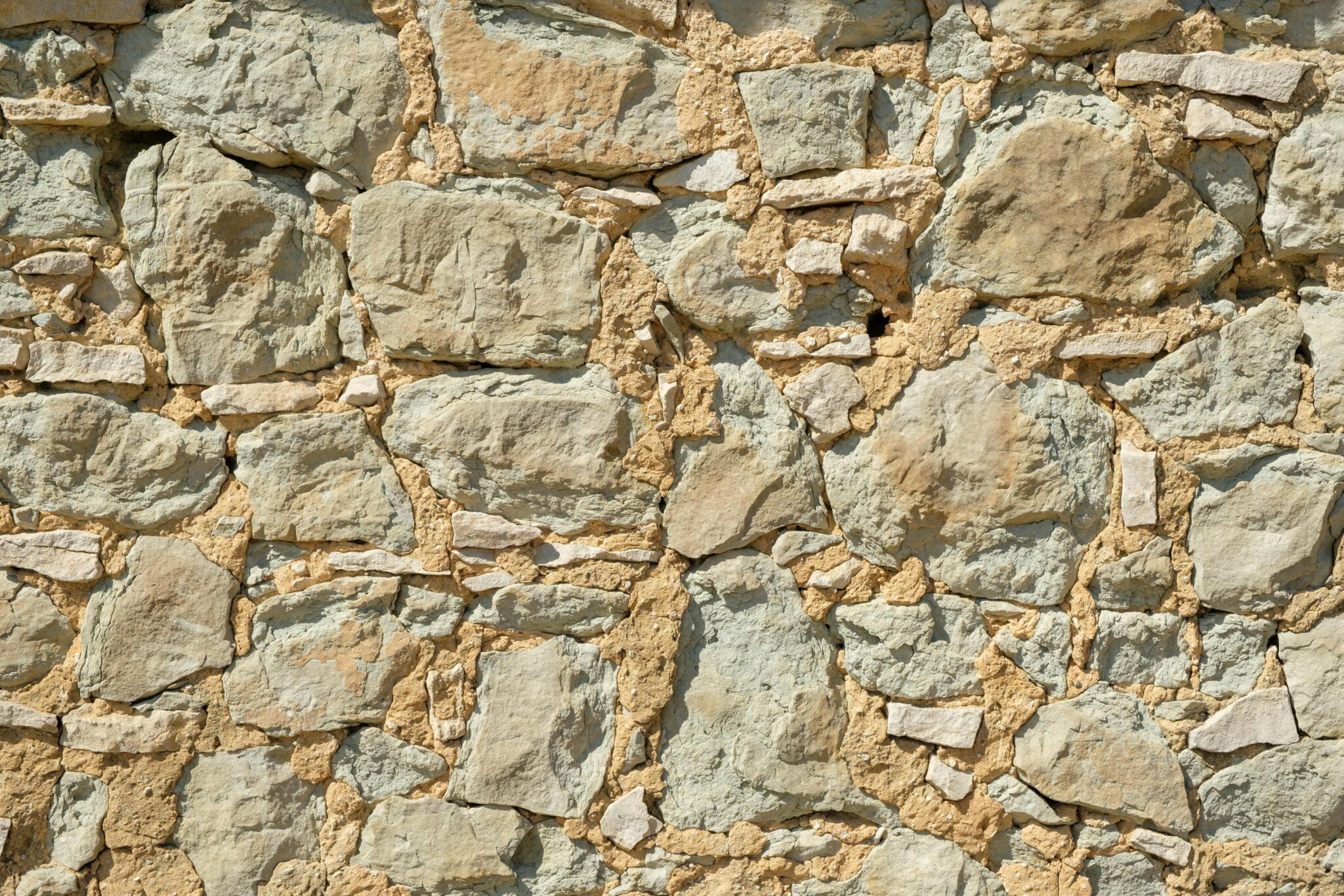 Detailed close-up of a rustic stone wall, ideal for textures and backgrounds.
